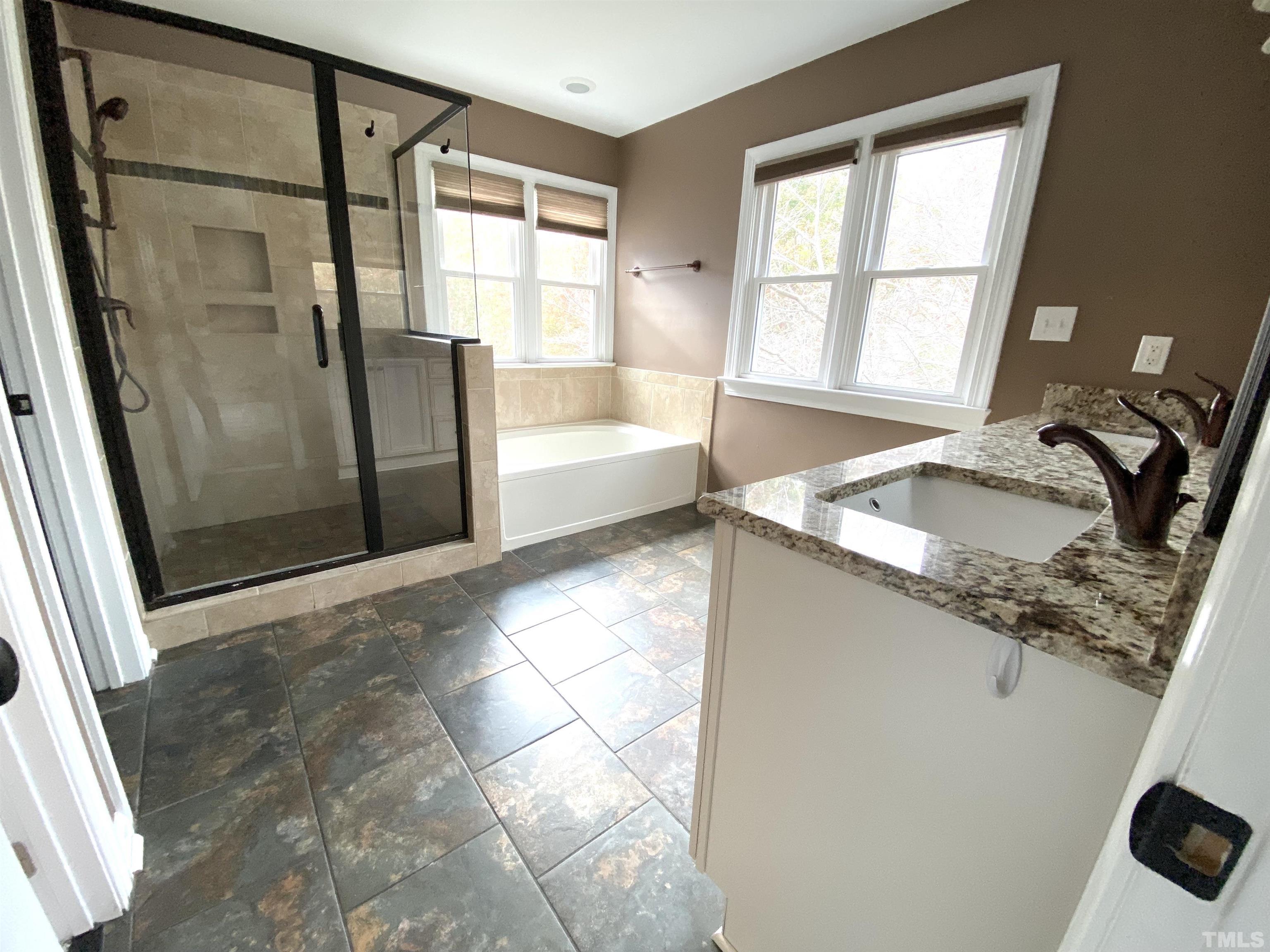 4313 Fowler Ridge Drive Raleigh, NC 27616 - Photo 12 of 30 a bathroom with a granite countertop sink and a shower