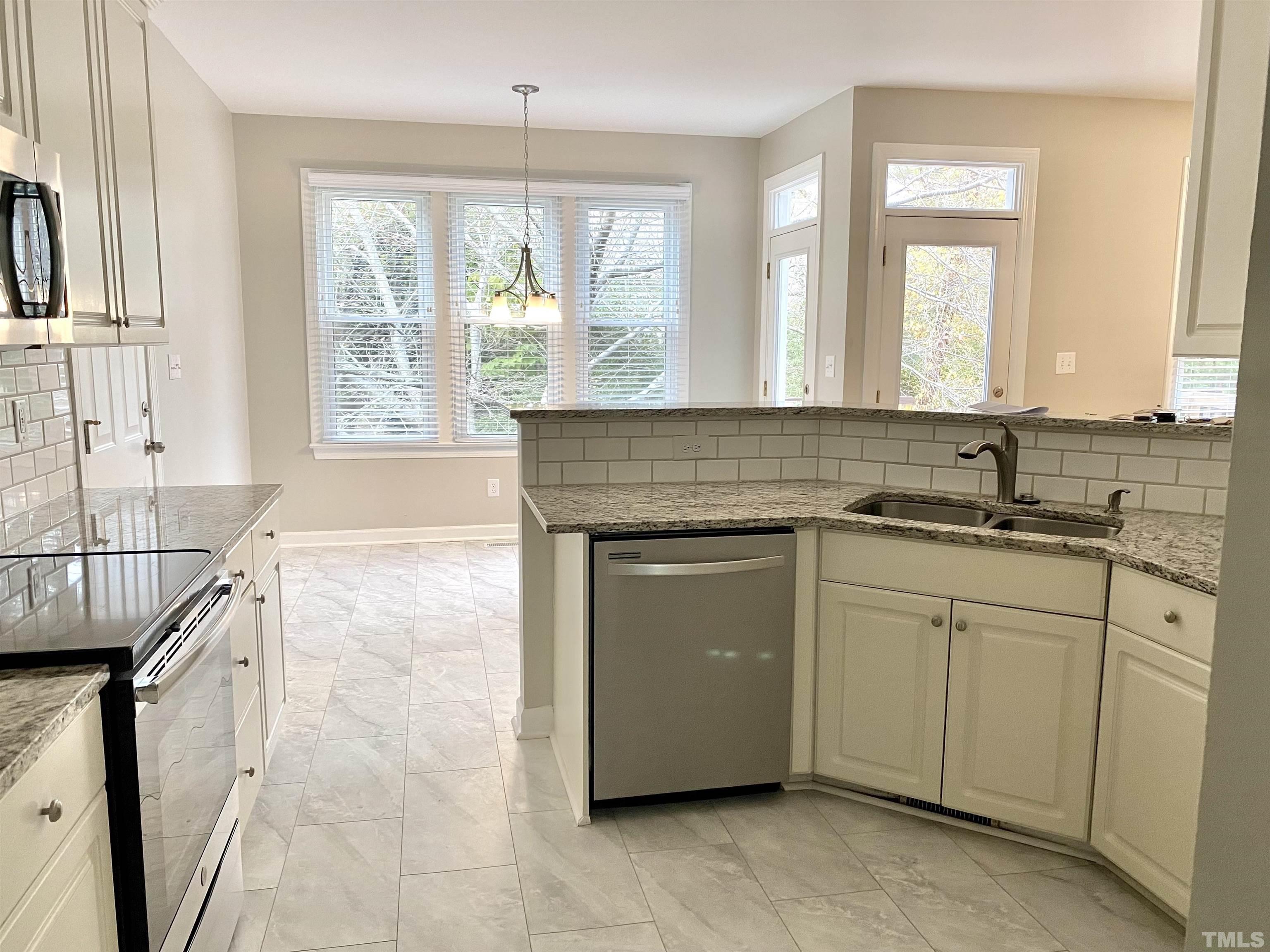 4313 Fowler Ridge Drive Raleigh, NC 27616 - Photo 6 of 30 a kitchen with granite countertop a sink and a stove