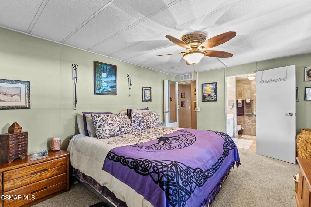 1550 Rory Lane, Unit 239 Simi Valley, CA 93063 - Photo 18 of 37 a bedroom with a bed and a chandelier