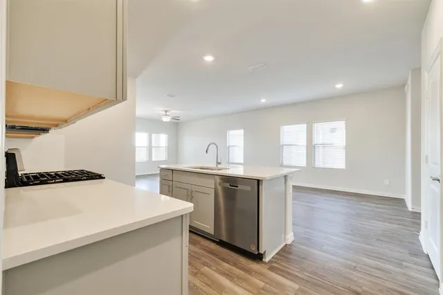 a large kitchen with a sink a window and stainless steel appliances