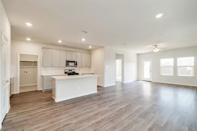 a kitchen with a refrigerator and a stove top oven