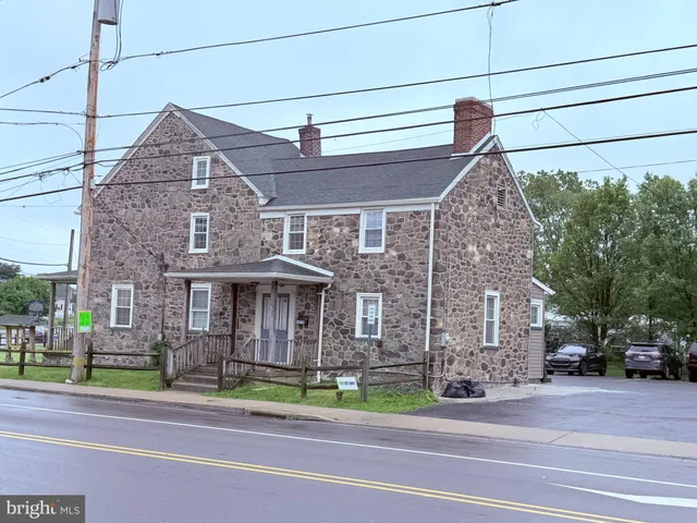 a front view of a house with a garden and plants