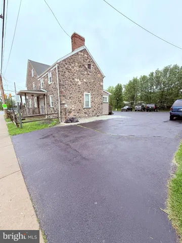 a view of a house with a yard and potted plants