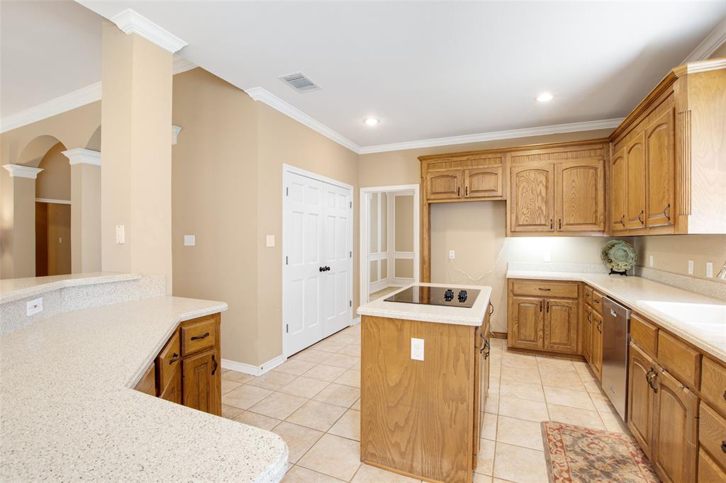 850 Turquoise Point Rockwall, TX 75032 - Photo 16 of 40 a kitchen that has a sink a stove and wooden cabinets