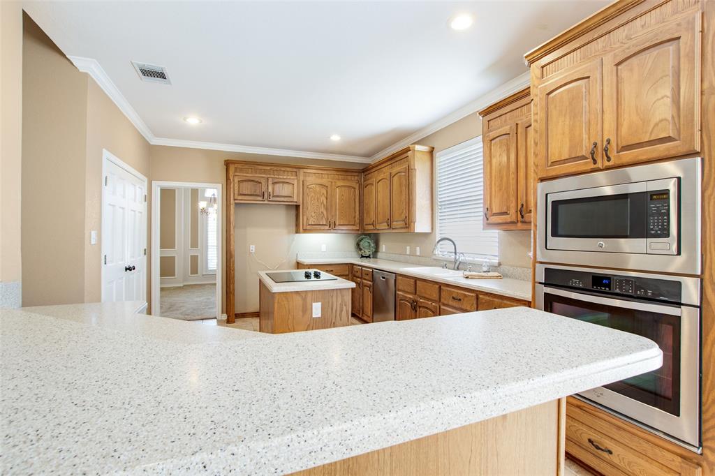850 Turquoise Point Rockwall, TX 75032 - Photo 17 of 40 a kitchen with stainless steel appliances granite countertop a sink stove and microwave