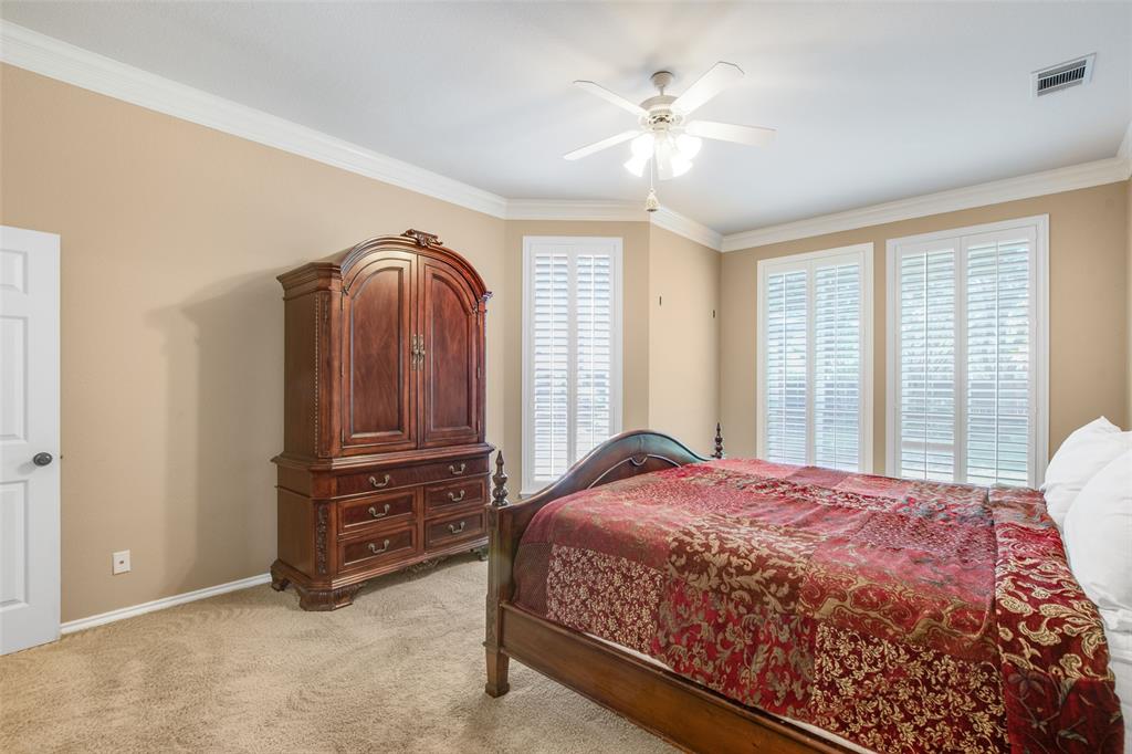 850 Turquoise Point Rockwall, TX 75032 - Photo 22 of 40 a bedroom with a bed a dresser and next to a window