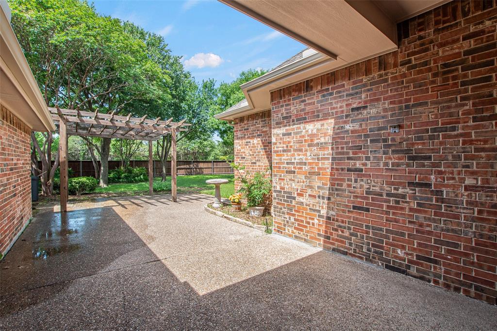 850 Turquoise Point Rockwall, TX 75032 - Photo 35 of 40 a view of a backyard with brick wall and a large tree