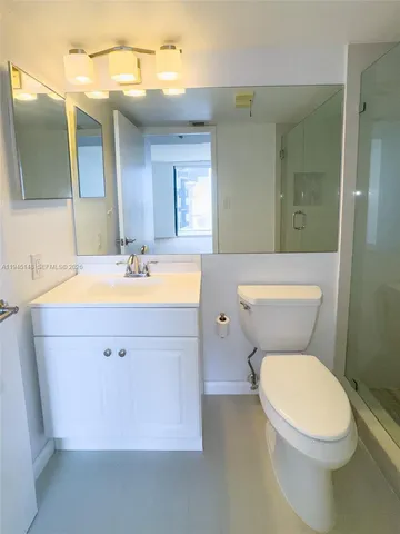 a bathroom with a toilet sink vanity and shower