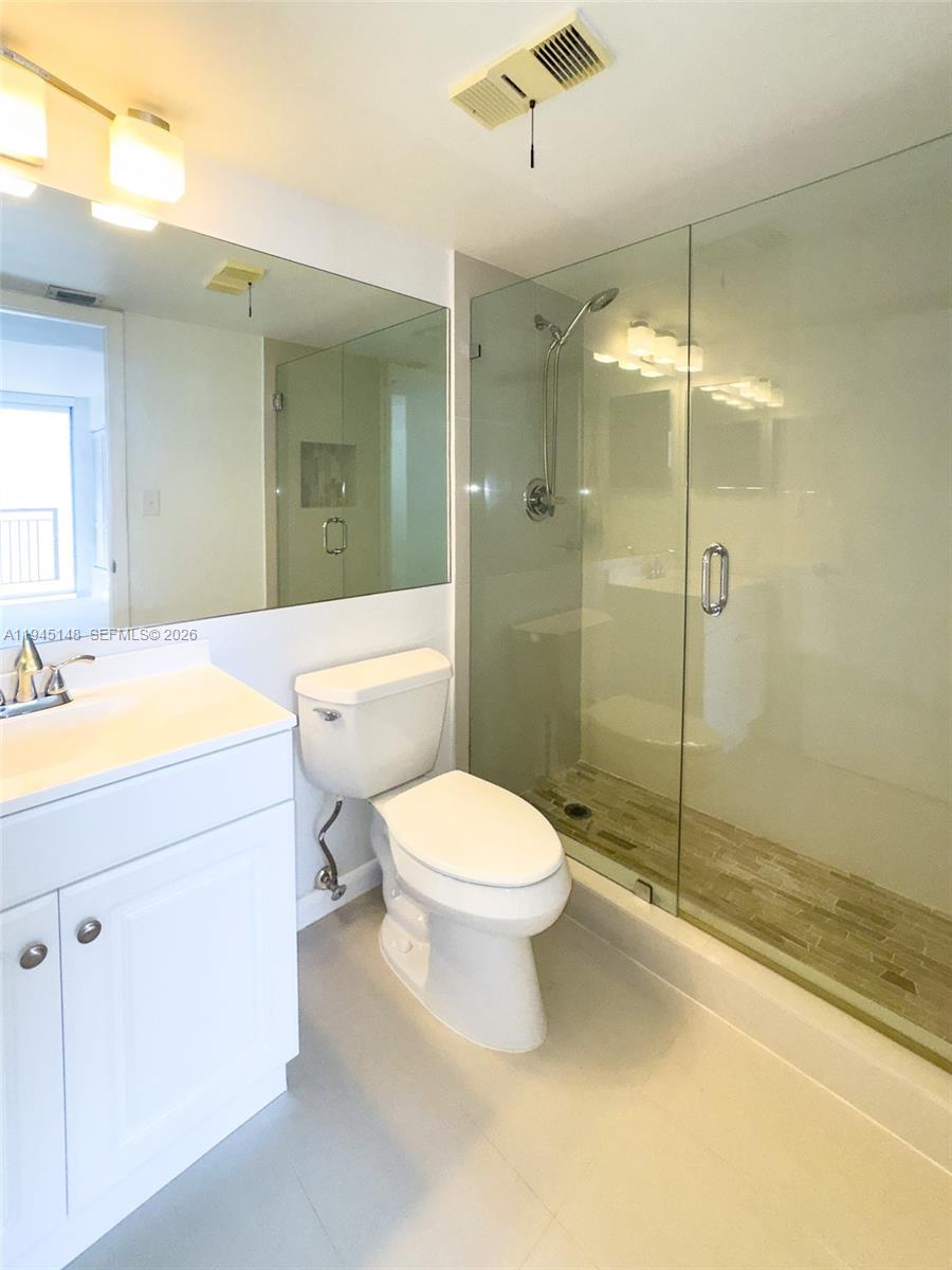 540 Brickell Key Drive, Unit 1201 Miami, FL 33131 - Photo 15 of 18 a bathroom with a toilet sink vanity and shower