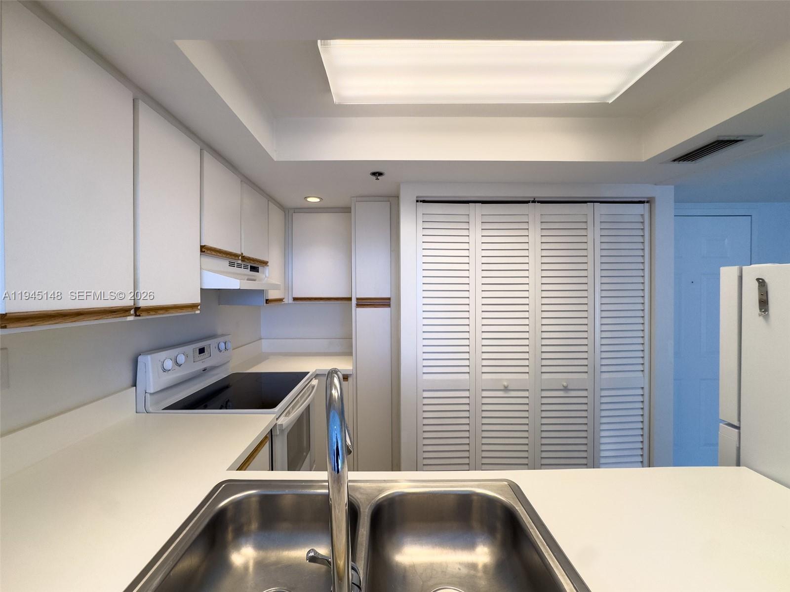 540 Brickell Key Drive, Unit 1201 Miami, FL 33131 - Photo 9 of 18 a kitchen with a refrigerator a sink and a stove top oven