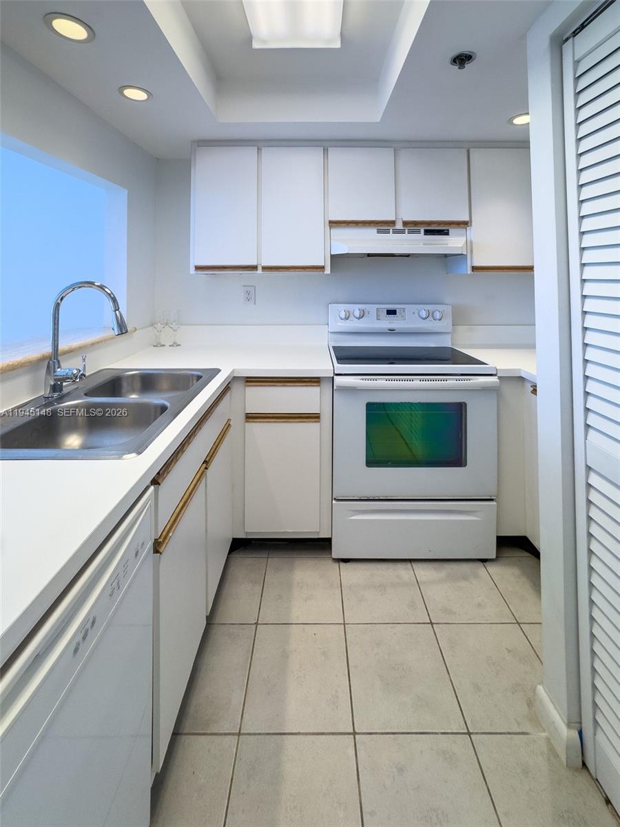 540 Brickell Key Drive, Unit 1201 Miami, FL 33131 - Photo 10 of 18 a kitchen with a sink a stove and cabinets