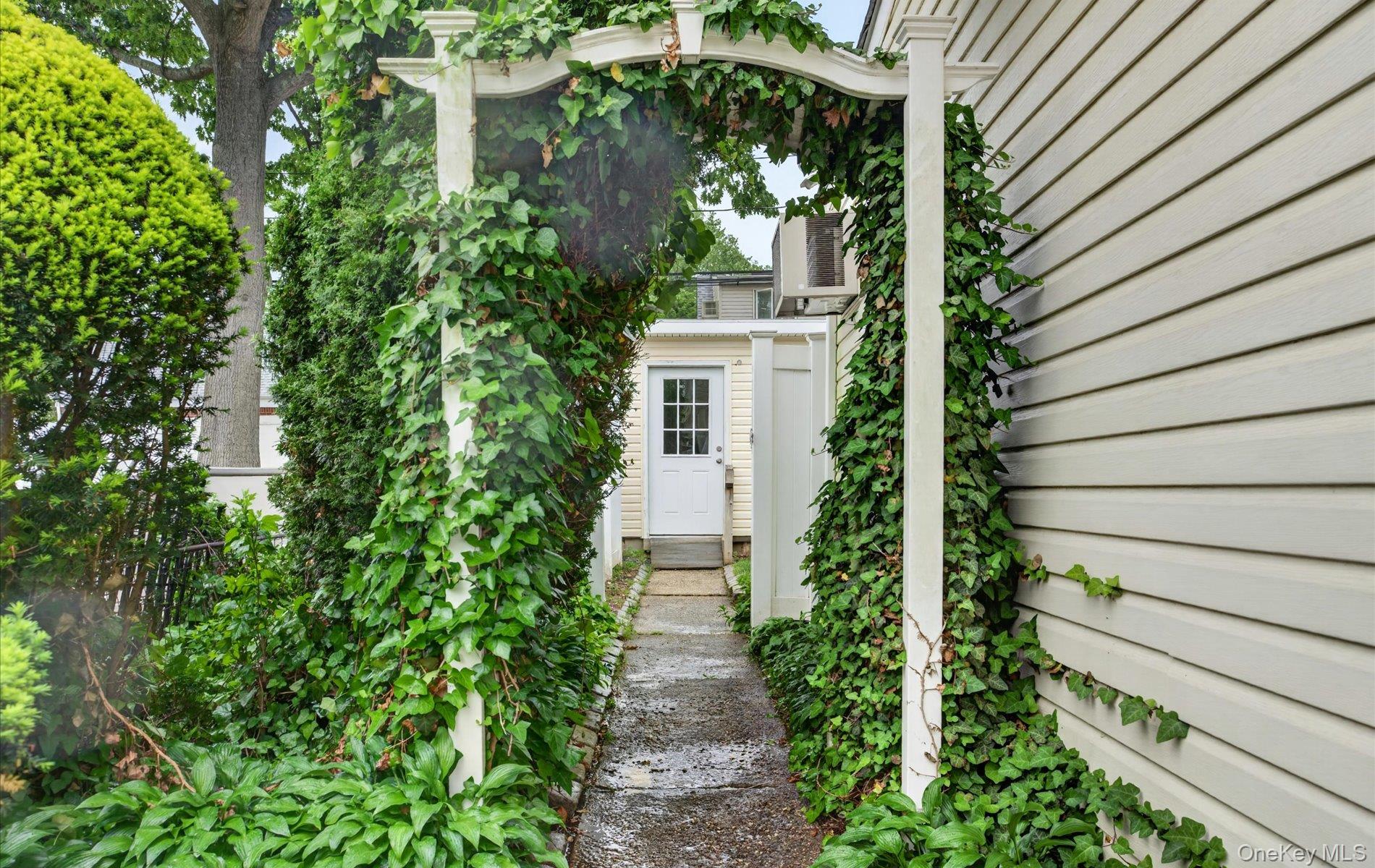 24 Purdue Road Glen Cove, NY 11542 - Photo 8 of 41 a view of a pathway with plants and large tree