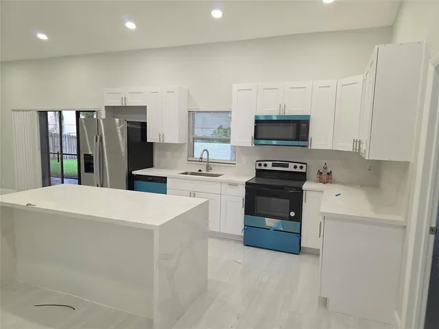 a kitchen with stainless steel appliances a refrigerator sink and stove