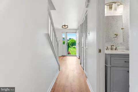 a view of a hallway with wooden floor and staircase