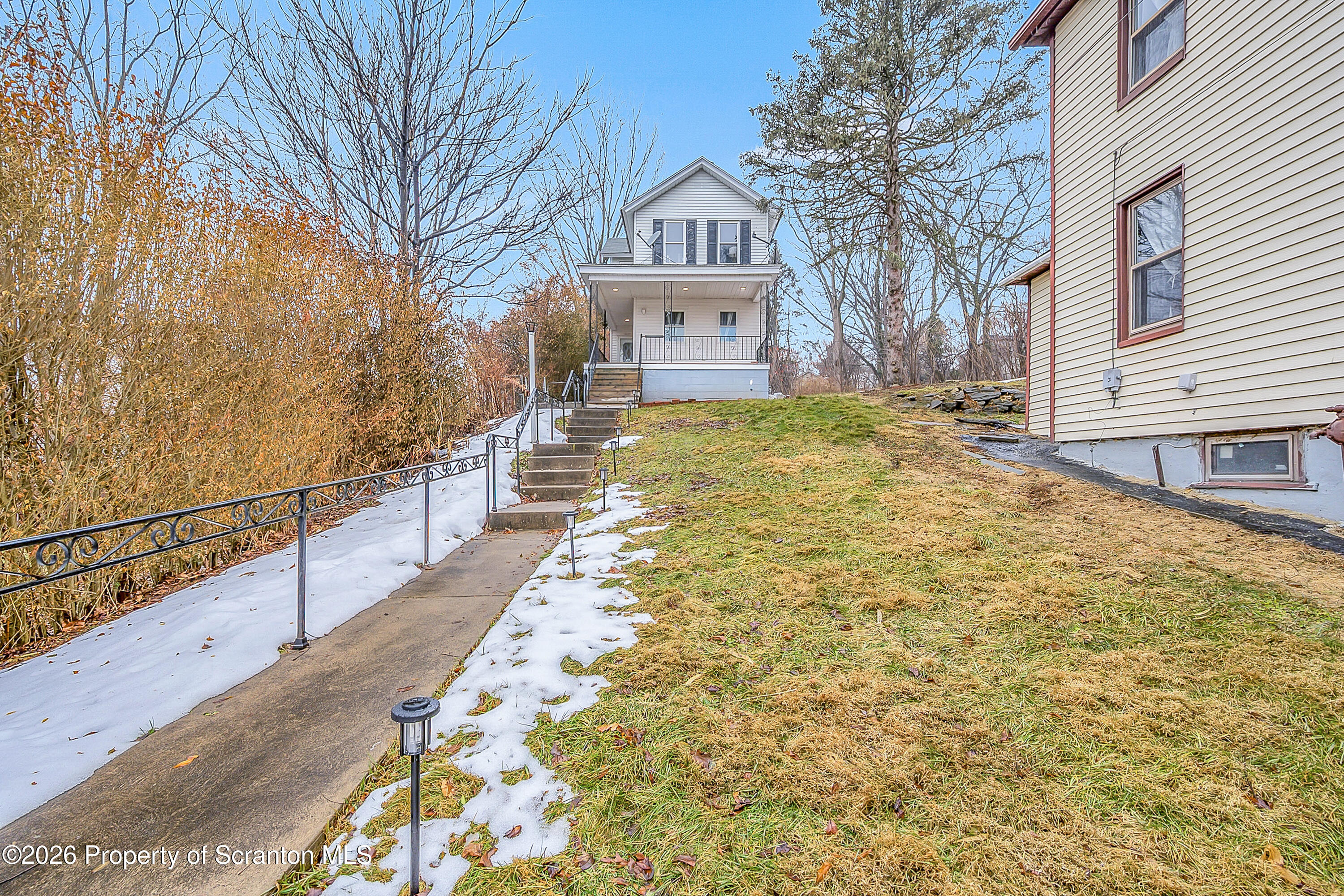215 North Fillmore Avenue Scranton, PA 18504 - Photo 1 of 25 a view of a house with a large tree and wooden fence