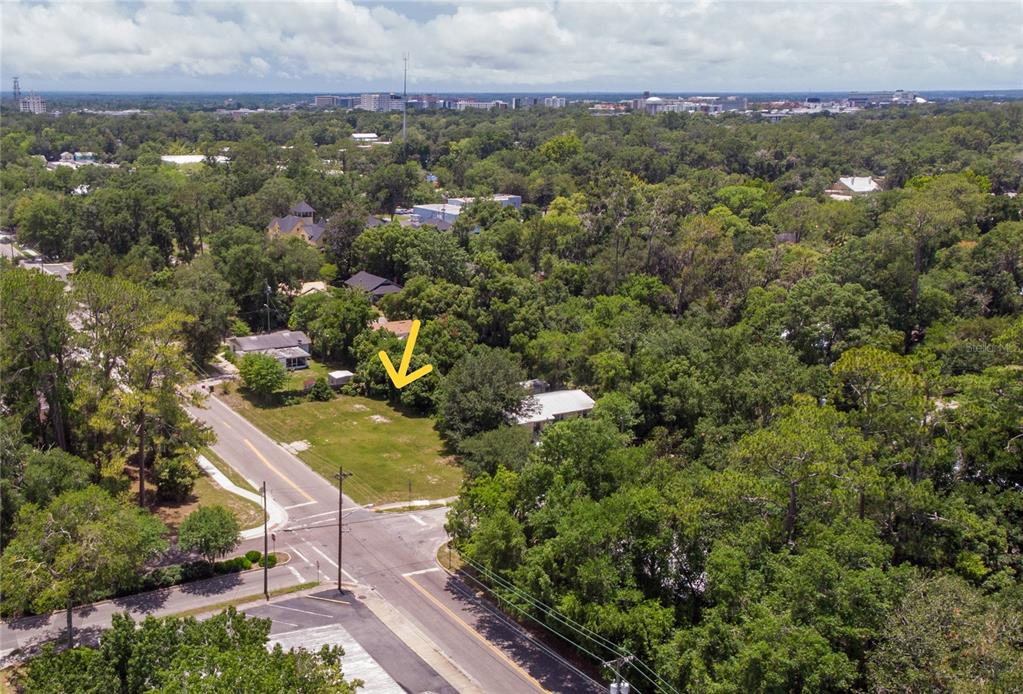 an aerial view of a residential houses with outdoor space and trees