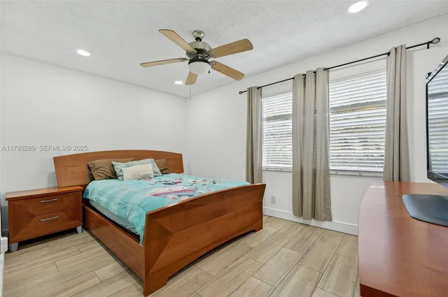 a bedroom with a bed and a ceiling fan