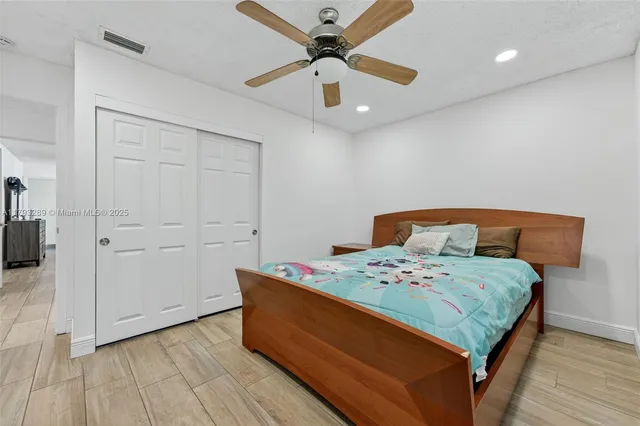 a bedroom with a bed and a ceiling fan
