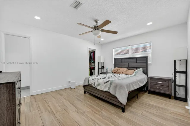 a bed sitting in a spacious bedroom next to a window