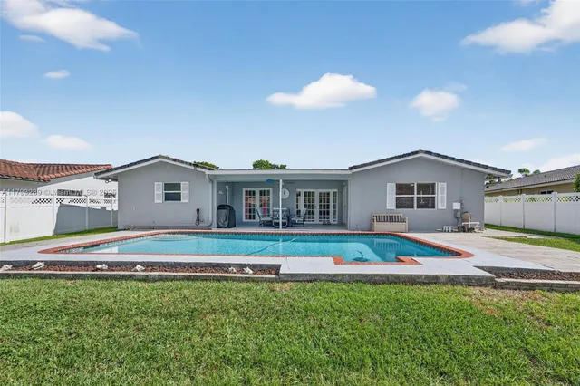 an aerial view of residential houses with outdoor space and trees