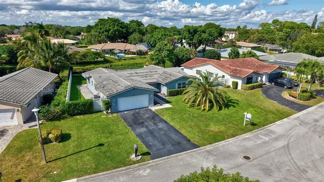 a aerial view of a house with a big yard and large trees