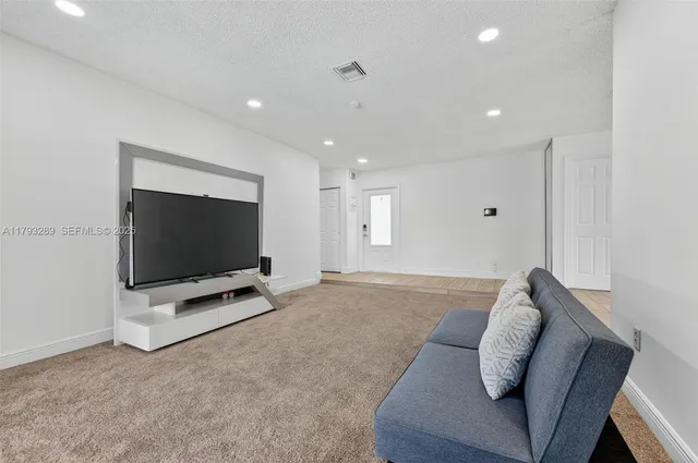 a living room with furniture and a floor to ceiling window