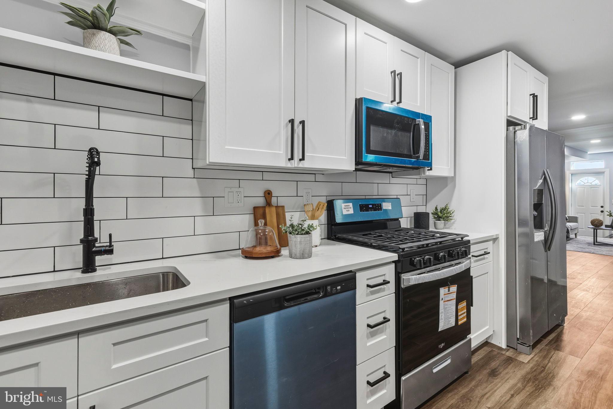 1618 North Regester Street Baltimore, MD 21213 - Photo 1 of 29 a kitchen with stainless steel appliances a stove a sink and a microwave