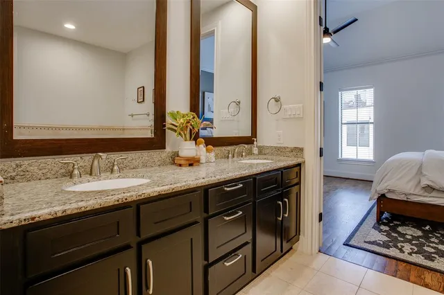 a bathroom with a granite countertop double vanity sink and a mirror
