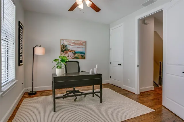 a view of a workspace with furniture and a window