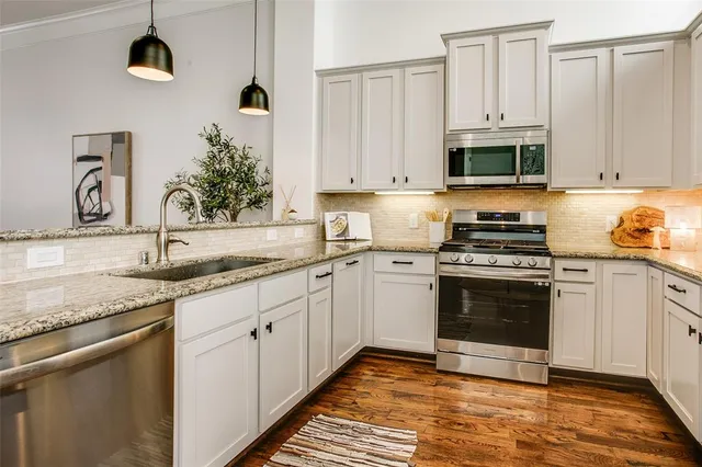 a kitchen with stainless steel appliances granite countertop a sink and a stove