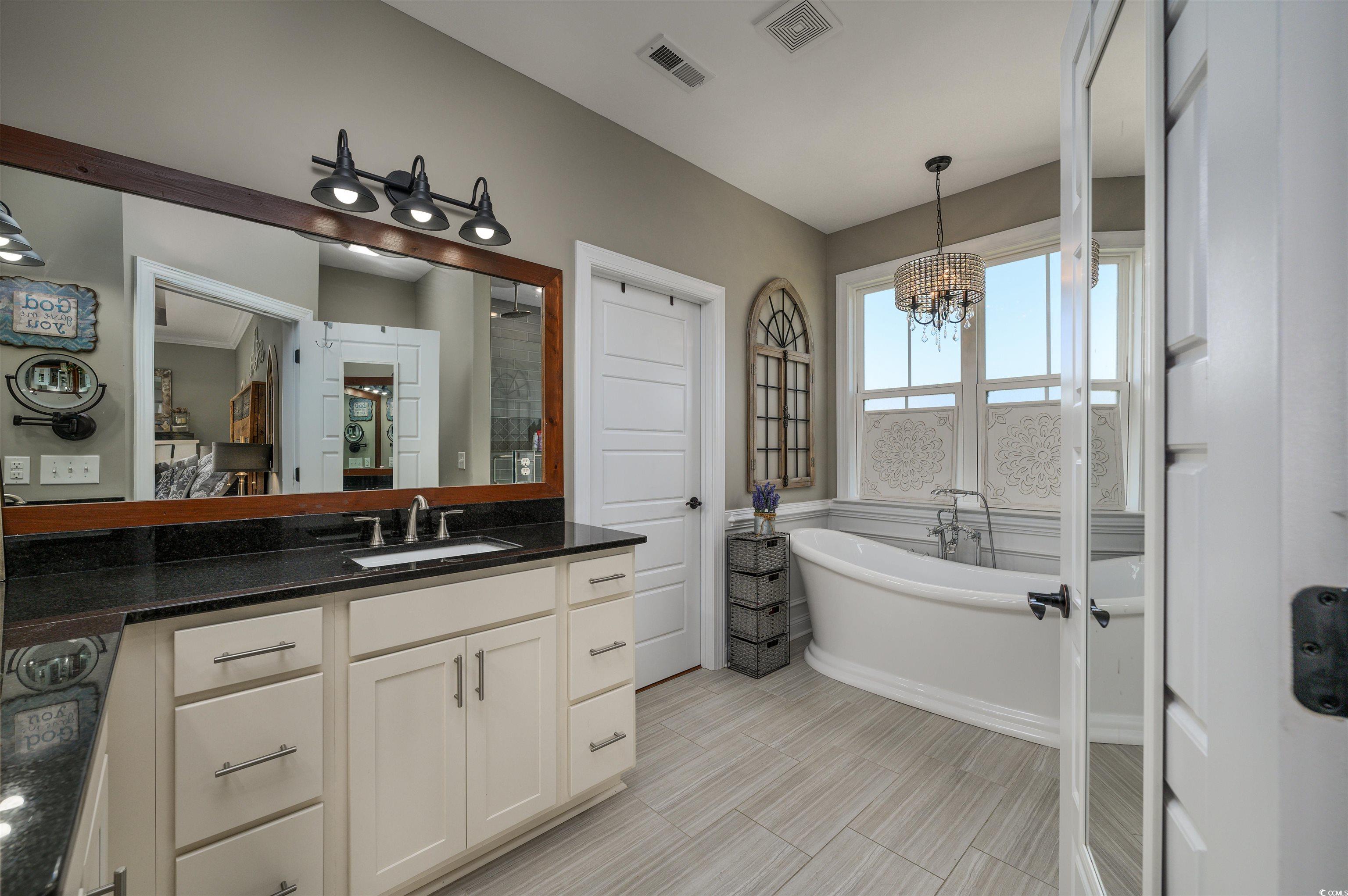 250 Samuel Road Loris, SC 29569 - Photo 16 of 38 Bathroom with vanity, a chandelier, and a washtub