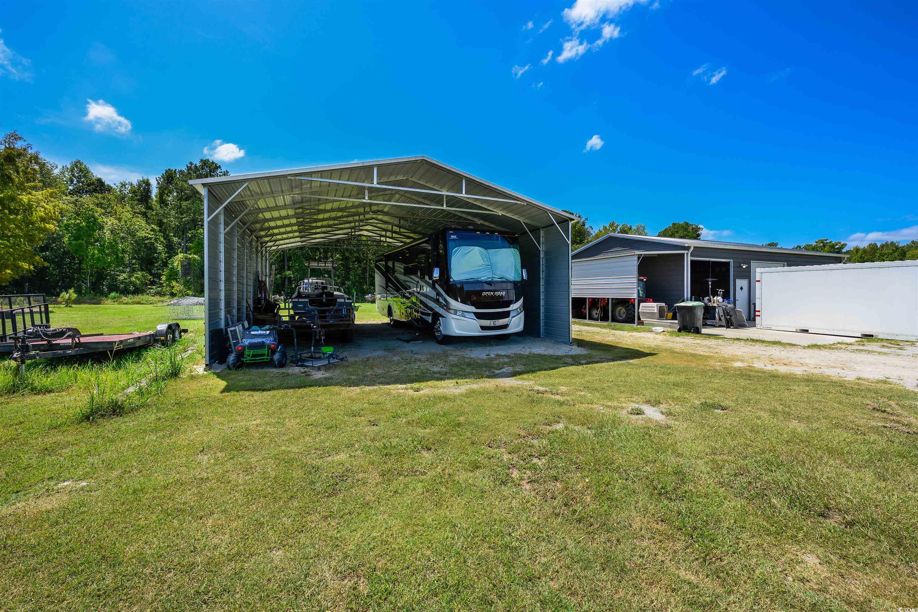 250 Samuel Road Loris, SC 29569 - Photo 35 of 38 View of vehicle parking with a lawn and a carport