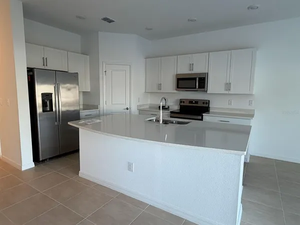 a kitchen with stainless steel appliances a refrigerator a stove a sink a microwave and cabinets