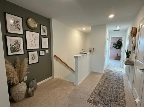 a view of hallway with furniture and a flat screen tv