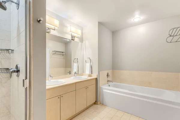 a bathroom with a tub a sink and mirrors