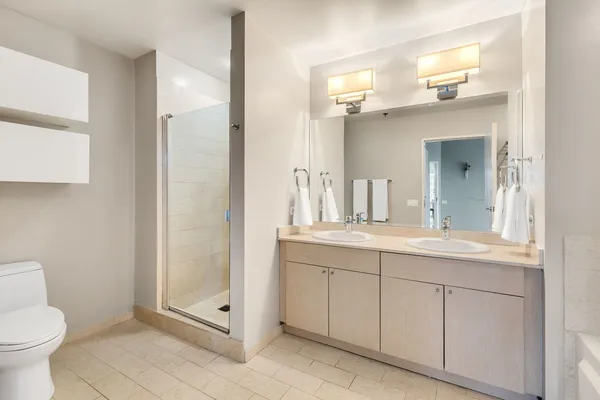 a bathroom with a granite countertop sink a toilet and a mirror