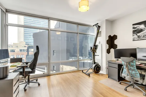 a view of a workspace with furniture and a window