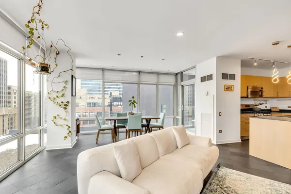 a living room with stainless steel appliances kitchen island granite countertop furniture and a large window