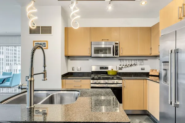 a kitchen with stainless steel appliances granite countertop a sink stove and refrigerator