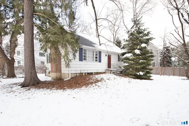 a front view of a house with a yard covered in snow