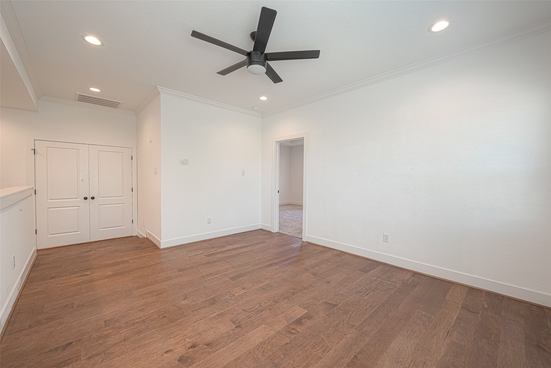 13419 Scott Street Houston, TX 77047 - Photo 11 of 23 an empty room with a ceiling fan and wooden floor