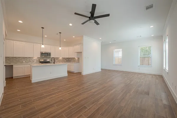 a view of kitchen with granite countertop window and white cabinets
