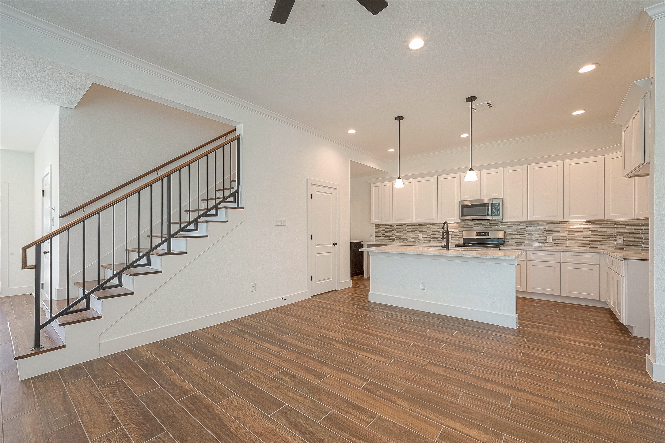 13419 Scott Street Houston, TX 77047 - Photo 8 of 23 a large white kitchen with wooden floors stainless steel appliances and white cabinets