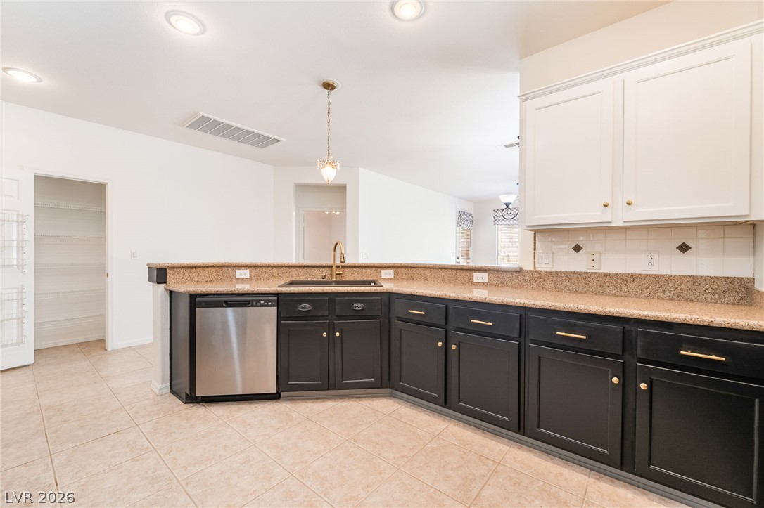 5389 Progresso Street Las Vegas, NV 89135 - Photo 11 of 41 A well-appointed kitchen showcases rich dark cabinetry paired with light granite countertops and a stainless steel dishwasher.