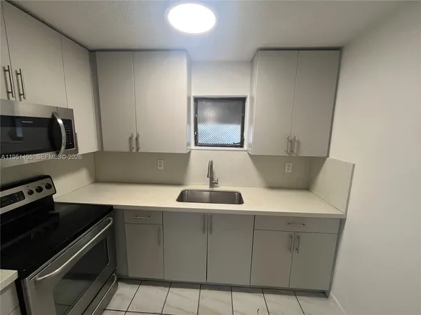 a kitchen with a sink and a stove top oven