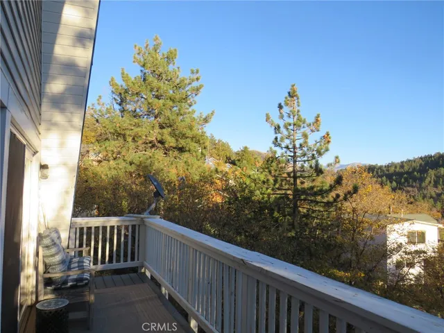 a balcony with wooden fence and trees
