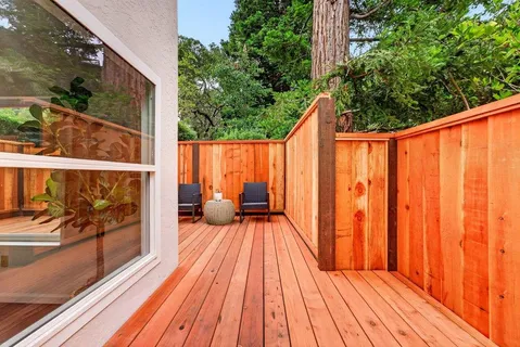 a balcony with wooden floor table and chairs
