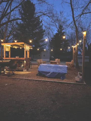 a view of a fire pit with large trees