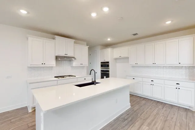 a kitchen with stainless steel appliances a sink window and cabinets