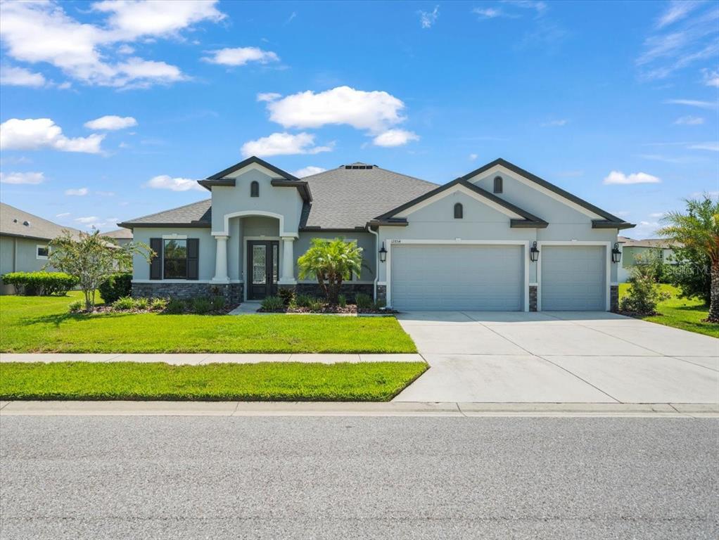 12854 Weatherstone Drive Spring Hill, FL 34609 - Photo 1 of 1 a front view of a house with a garden and yard